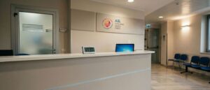 Il bancone di uno sportello della Asl Lanciano Vasto Chieti, senza persone, con il logo aziendale alla parete